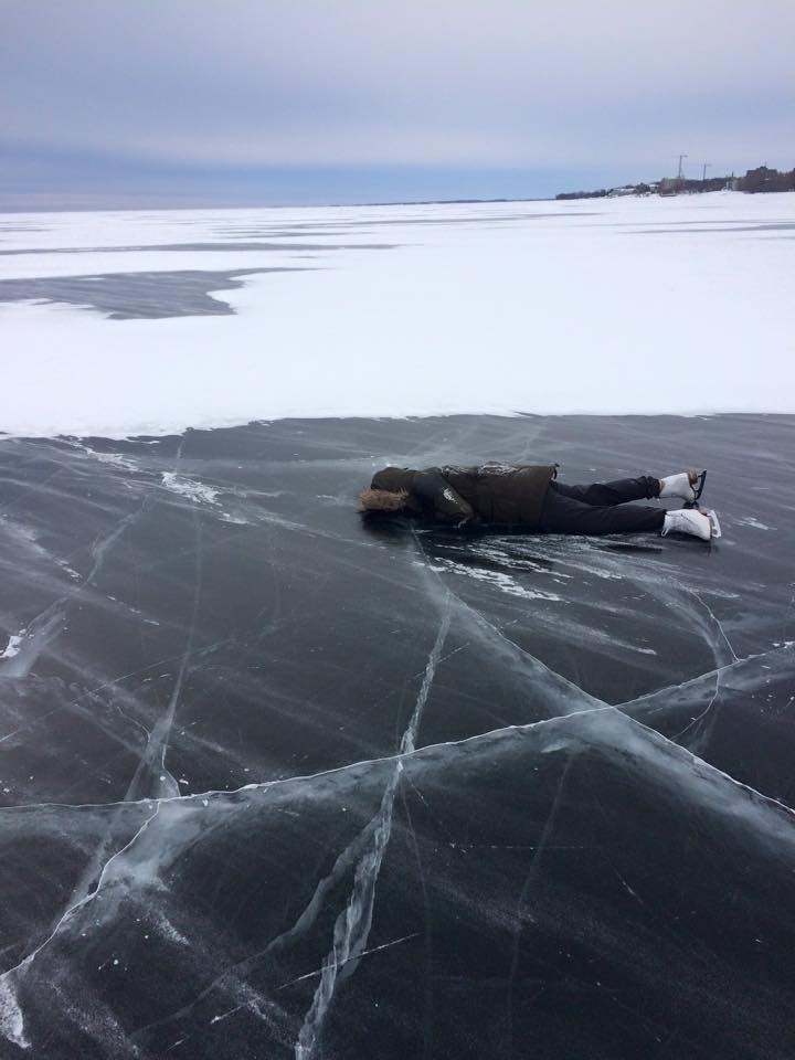 Skater lying down on the ice on a lake