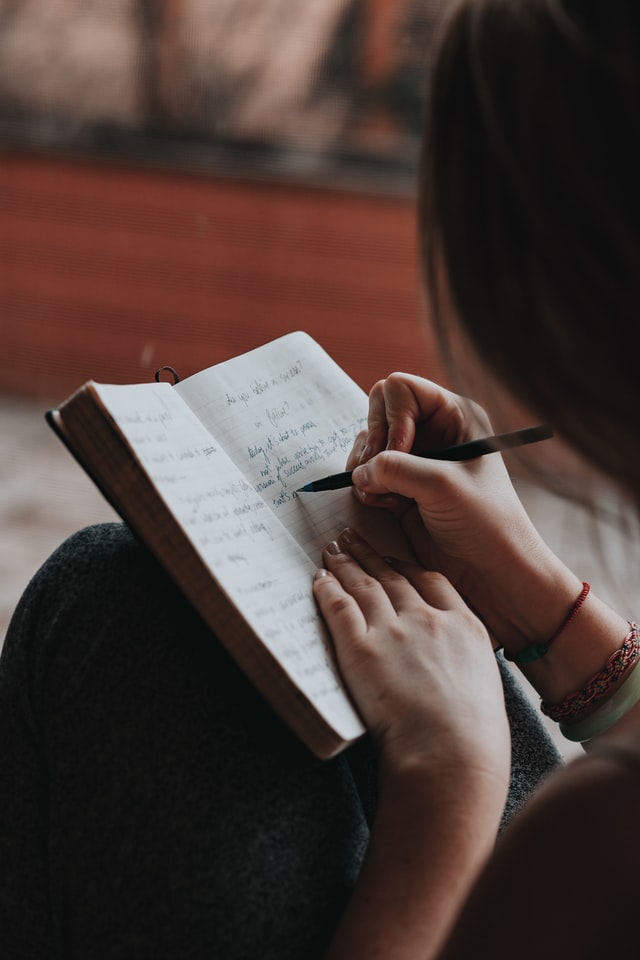 woman writing goals in a notebook