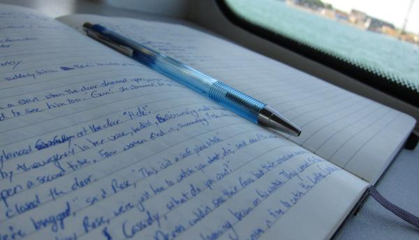 notebook with writing and a pen