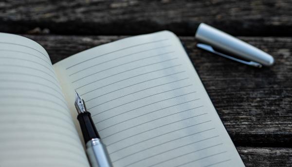 open notebook with pen between pages