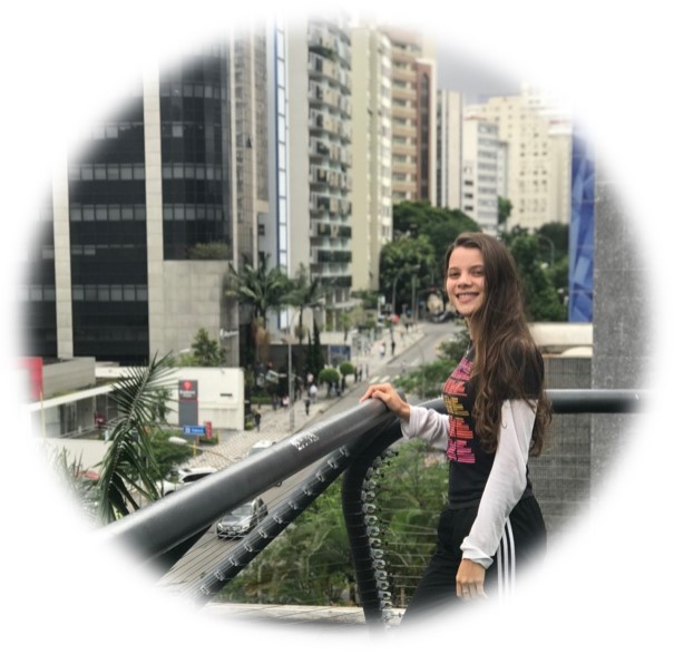 "Younger Maria standing on a balcony in a busy city street in Brazil"