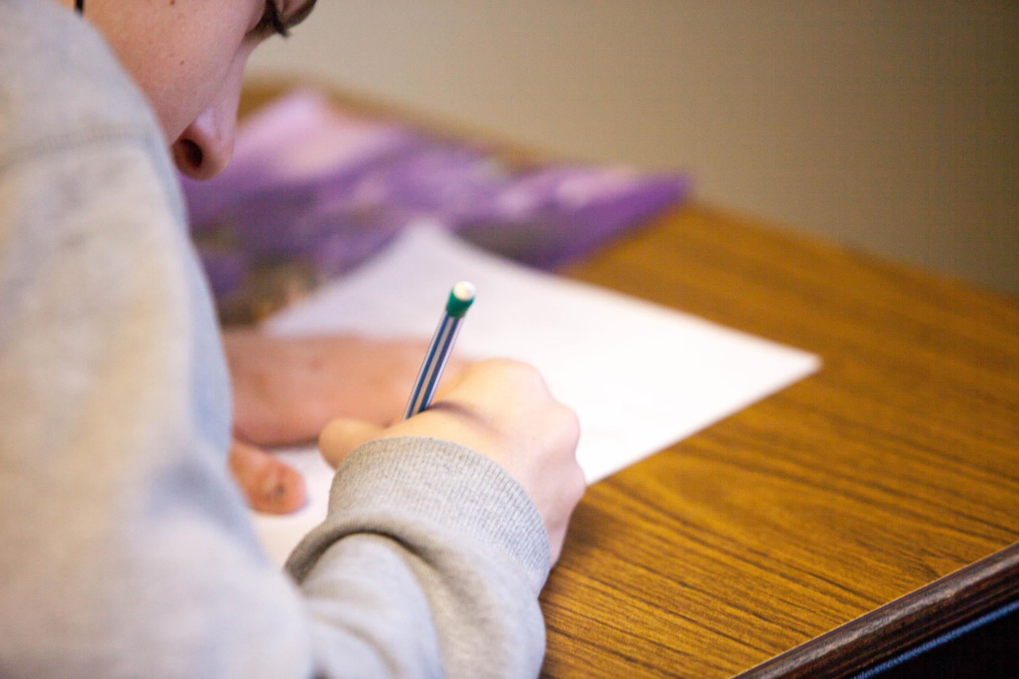 student writes in notebook