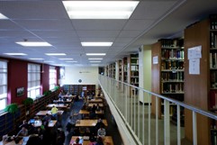 Stacks and students studying below in library