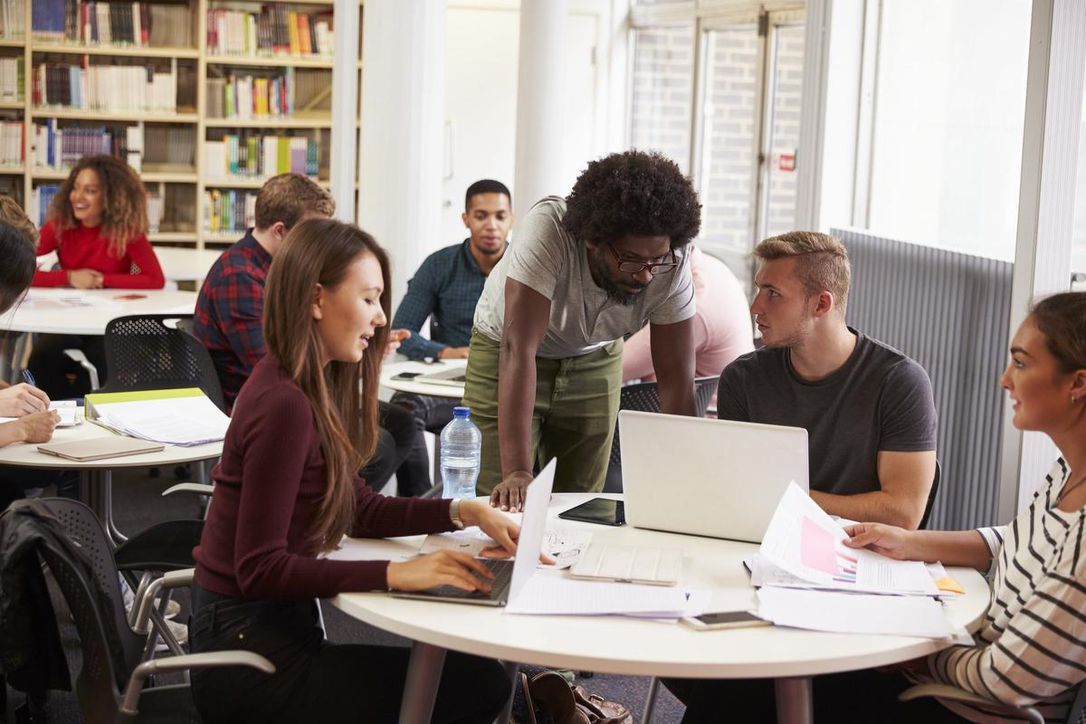 Person helping out a group of students